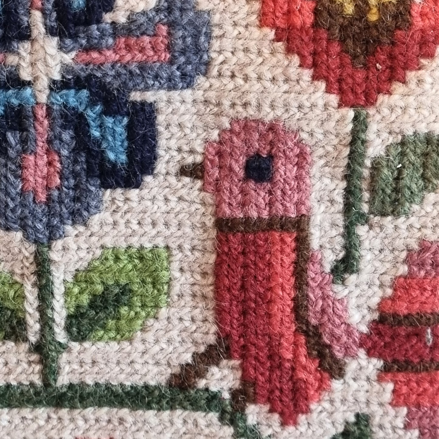 Close-up detail of geometric border in navy, olive green and burgundy with diamond and cross motifs