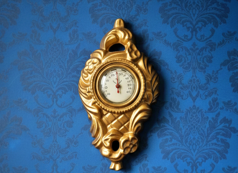 Vintage Neo-Baroque Wall Thermometer: Gold Cast Metal, Made in Sweden with authentic vintage charm and timeless elegance on blue wallpaper background
