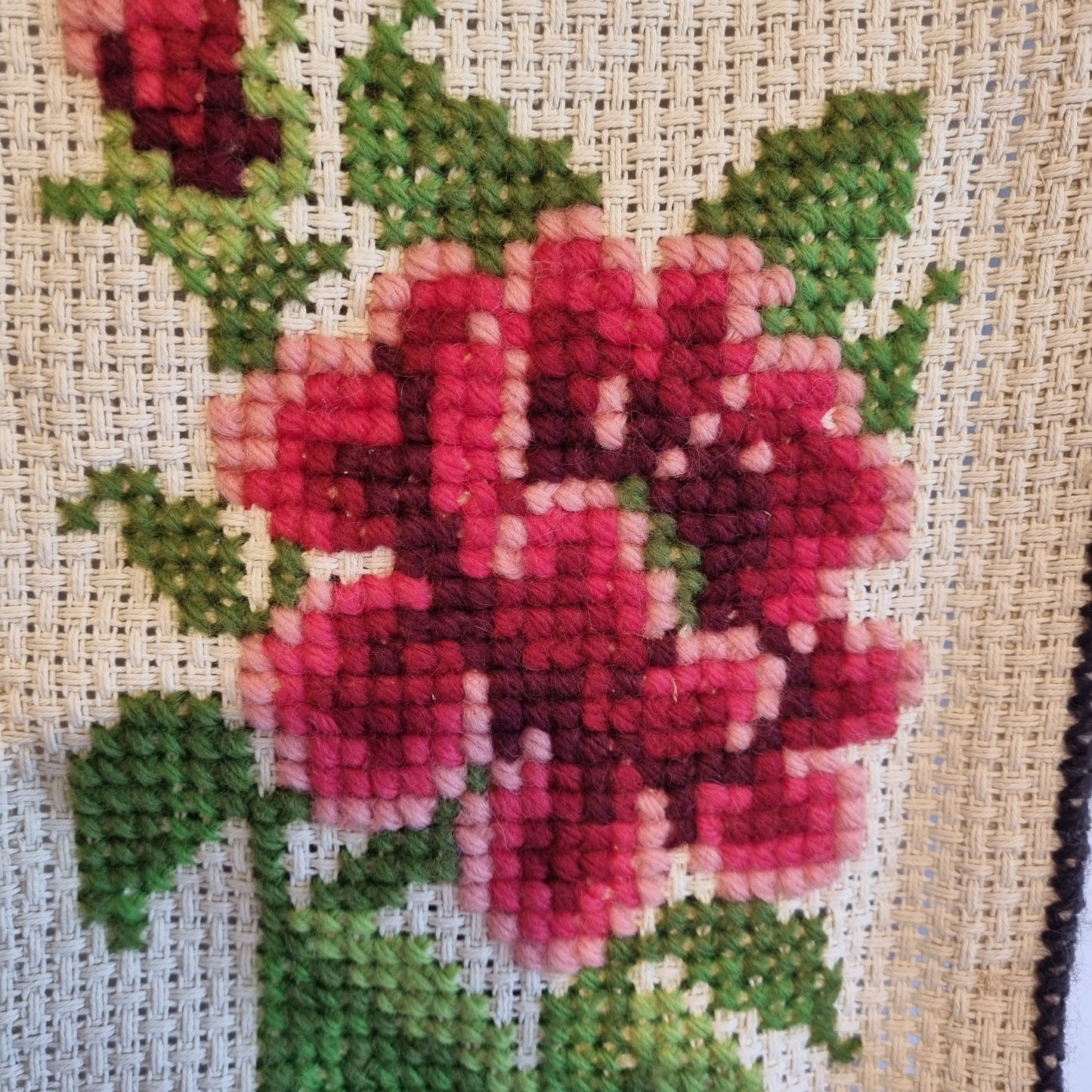 Close-up detail of sky blue forget-me-nots with yellow centres in cross-stitch