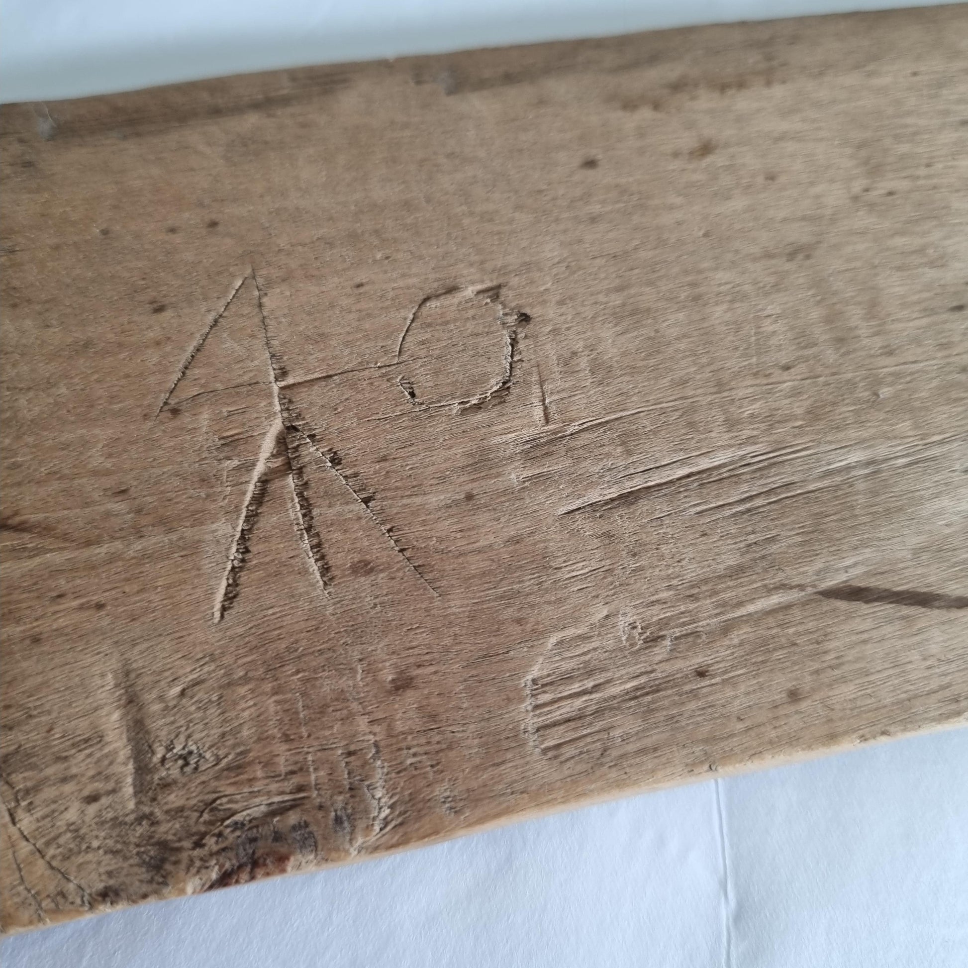 Close-up of wood carving detail on Antique Hand-Carved Butter Paddle: 1806 Scandinavian Folk Art Decor showing rustic texture and markings.