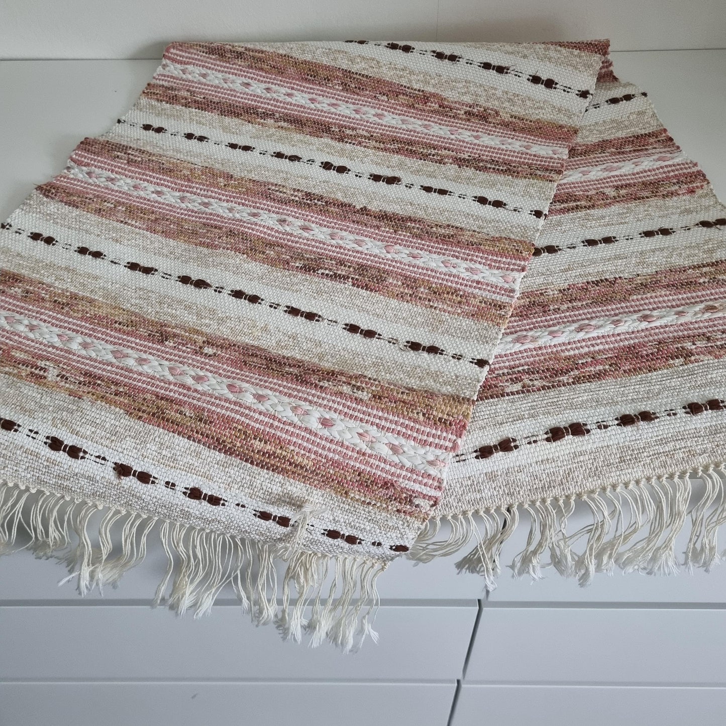 Handwoven Swedish Table Runner: Scandi Boho Pastel Decor Rug with soft pink, beige, and white stripes and fringe edges.