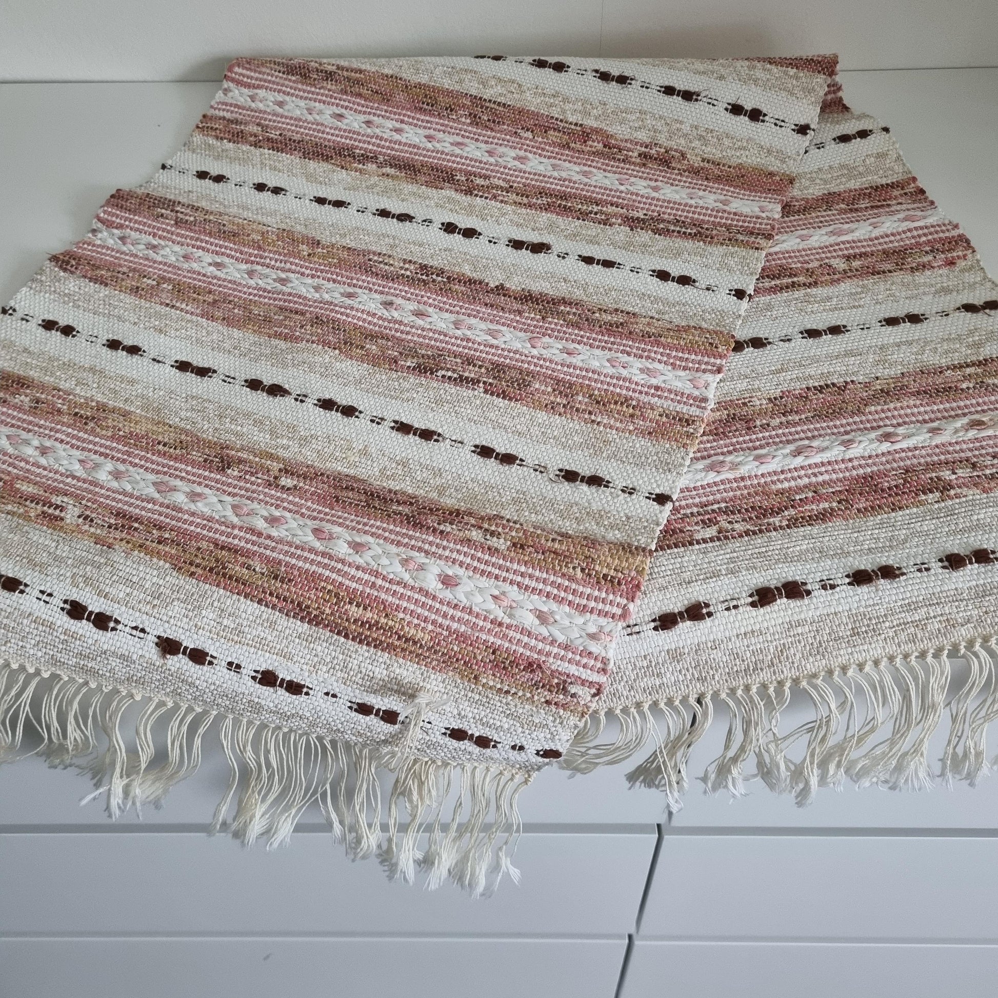 Handwoven Swedish Table Runner: Scandi Boho Pastel Decor Rug with soft pink, beige, and white stripes and fringe edges.