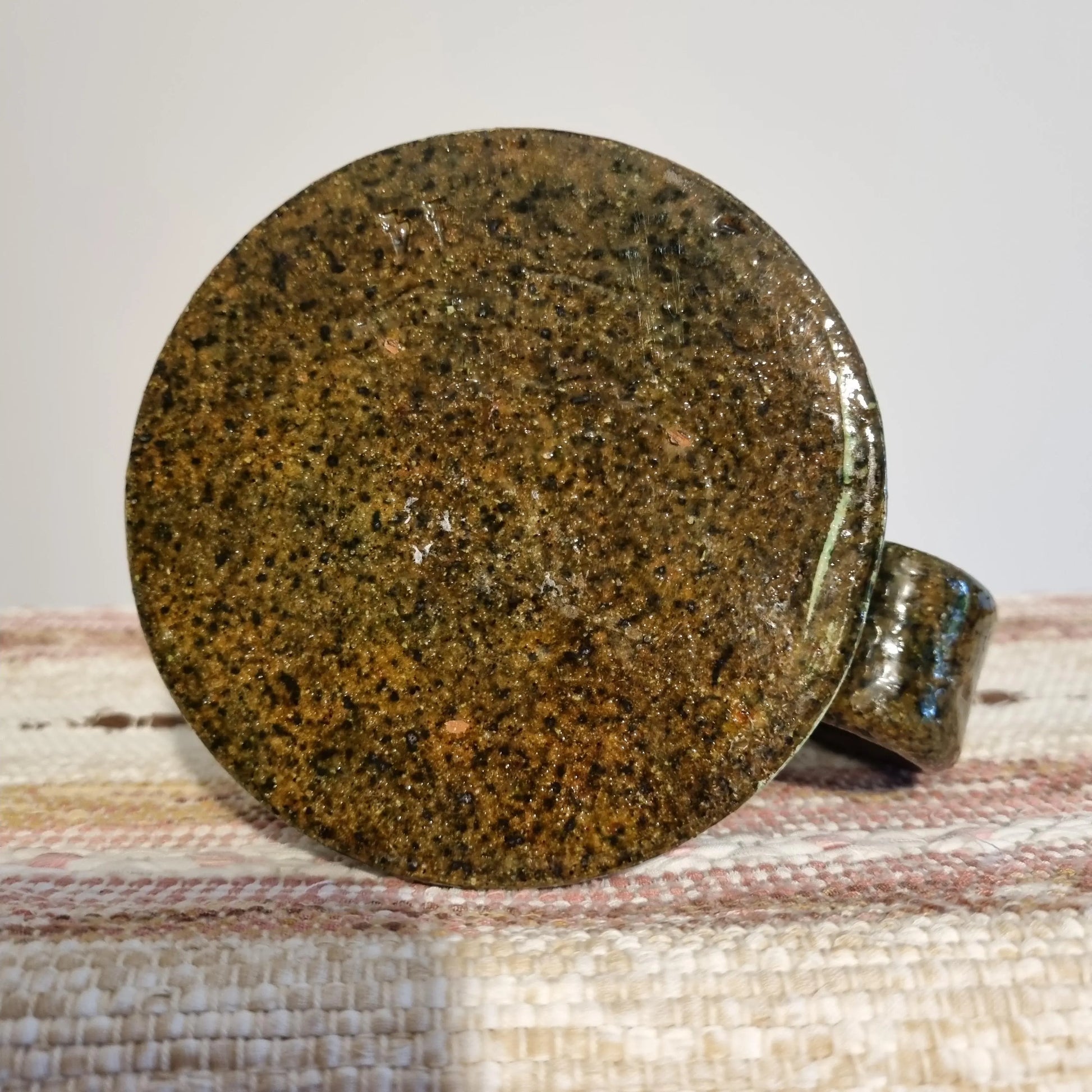 Krukmakeri Ystad Swedish Stoneware Mug – Speckled Green Glaze, Handmade shown from the bottom with textured stoneware surface