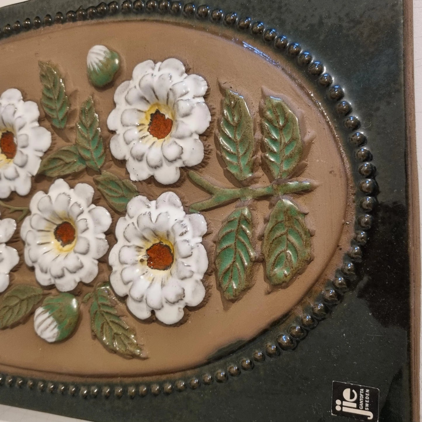 Vintage JIE Gantofta Ceramic Wall Plaque - Aimo Nietosvuori Design with embossed white flowers and green leaves on brown background