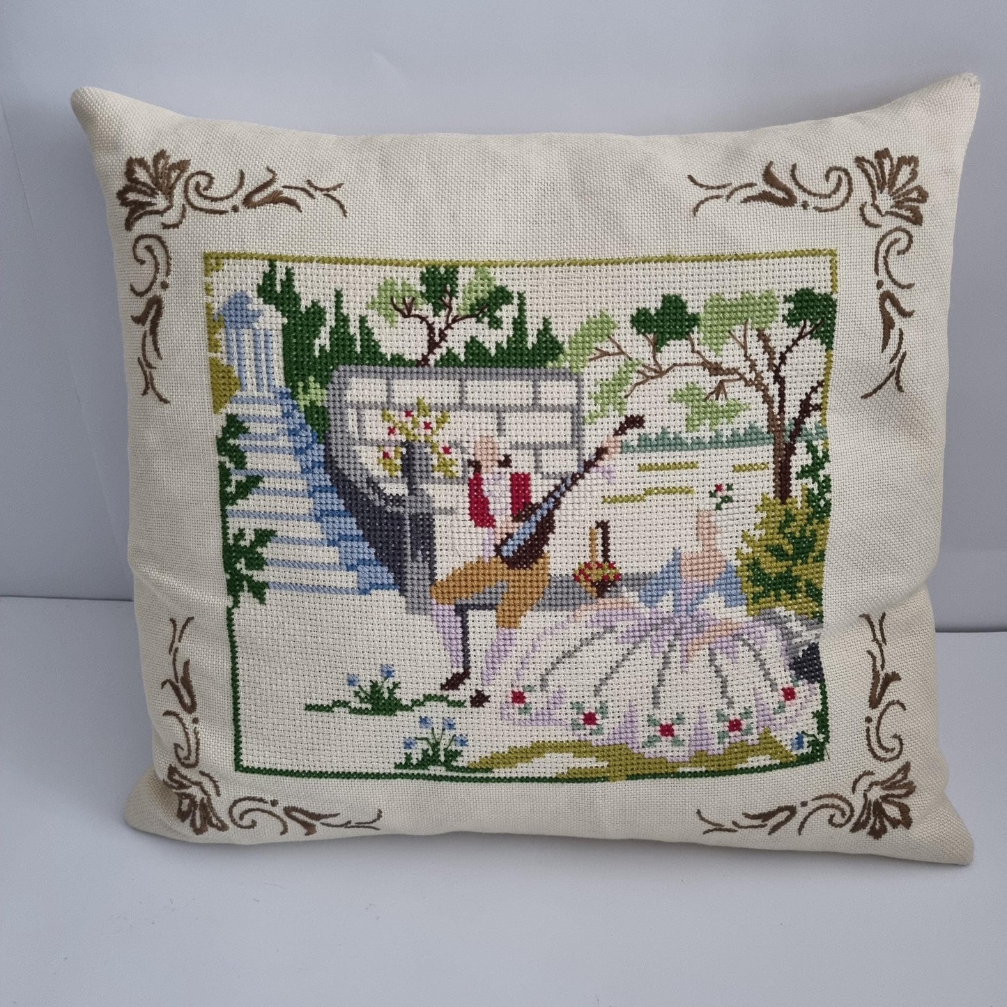 Vintage Hand Embroidered Needlepoint Pillow: Romantic Garden Scene with a couple dancing and floral accents on cream fabric.