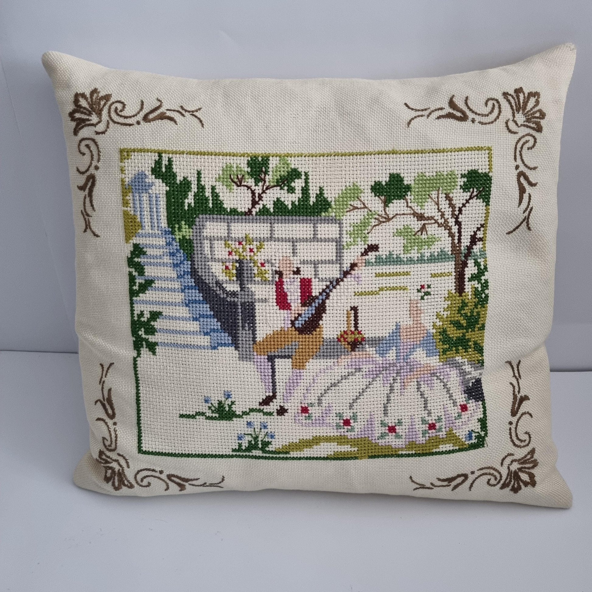 Vintage Hand Embroidered Needlepoint Pillow: Romantic Garden Scene with a couple dancing and floral accents on cream fabric.