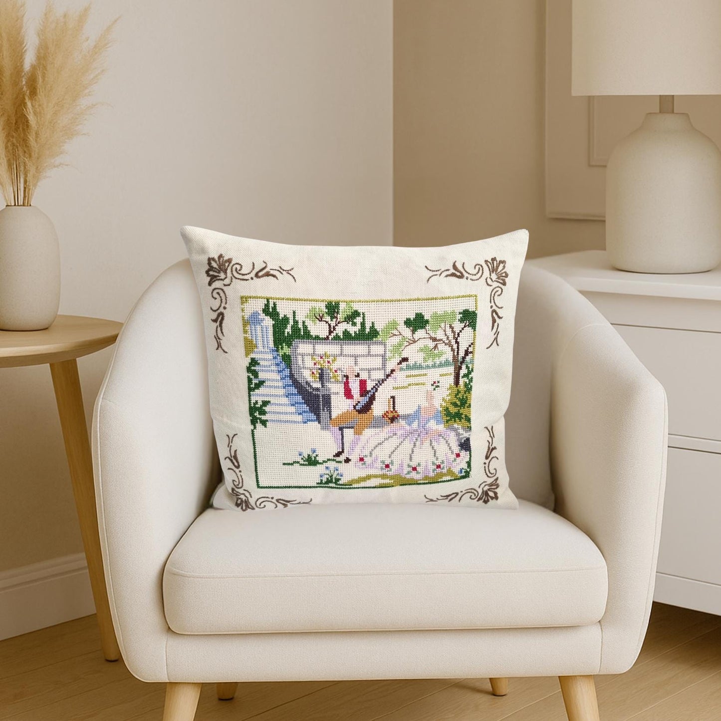Vintage Hand Embroidered Needlepoint Pillow: Romantic Garden Scene with dancers on a white armchair in cozy room.