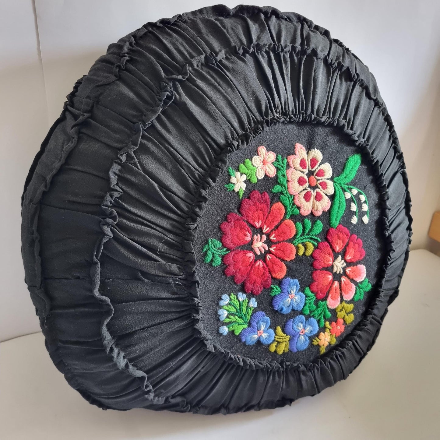 Vintage Embroidered Floral Throw Pillow: Black Ruffled Cushion with colorful hand-stitched flowers and textured fabric design
