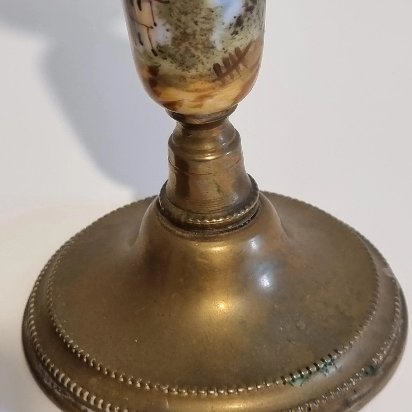 Vintage Brass Candle Holders: Hand-Painted European Village Scene, 1920s Pair with intricate brass base detail and painted village imagery.