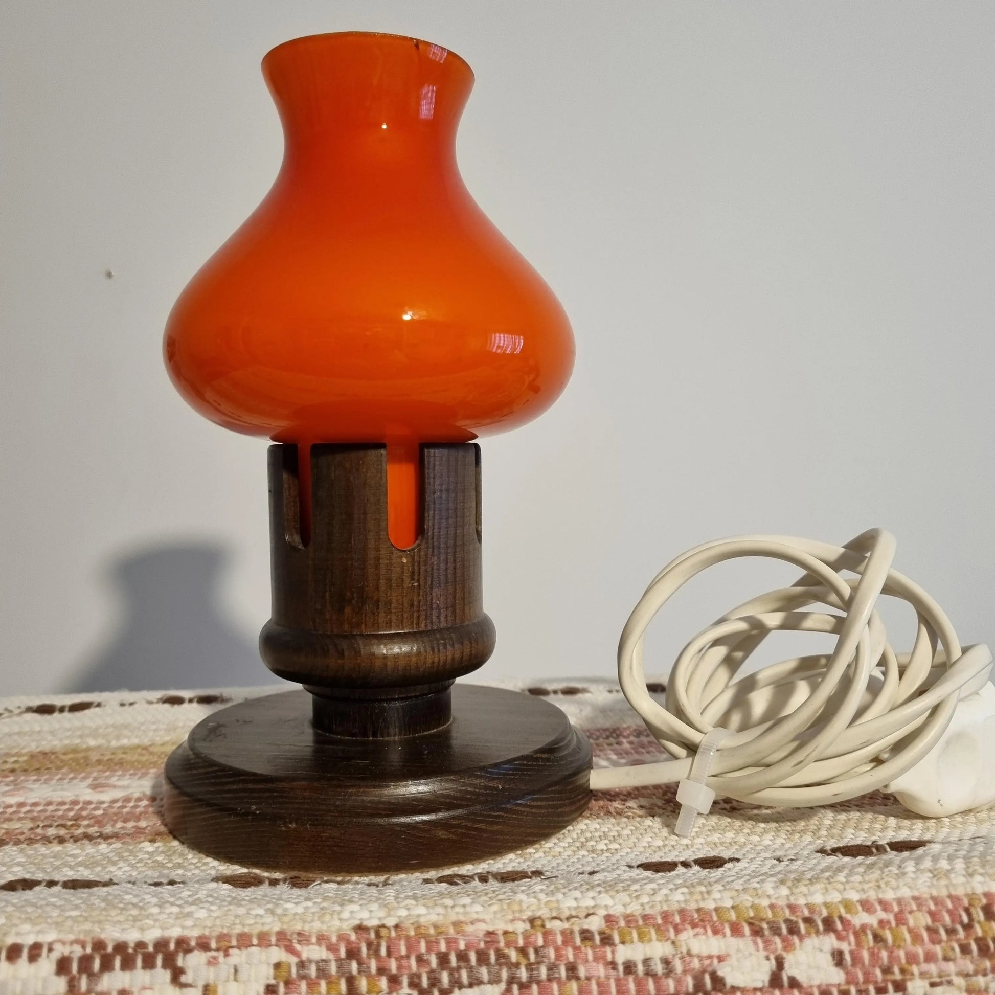 Vintage Erik Höglund Table Lamp – Orange Cased Glass & Pine, Marksöjd Boda, Sweden c. 1970 on woven fabric background