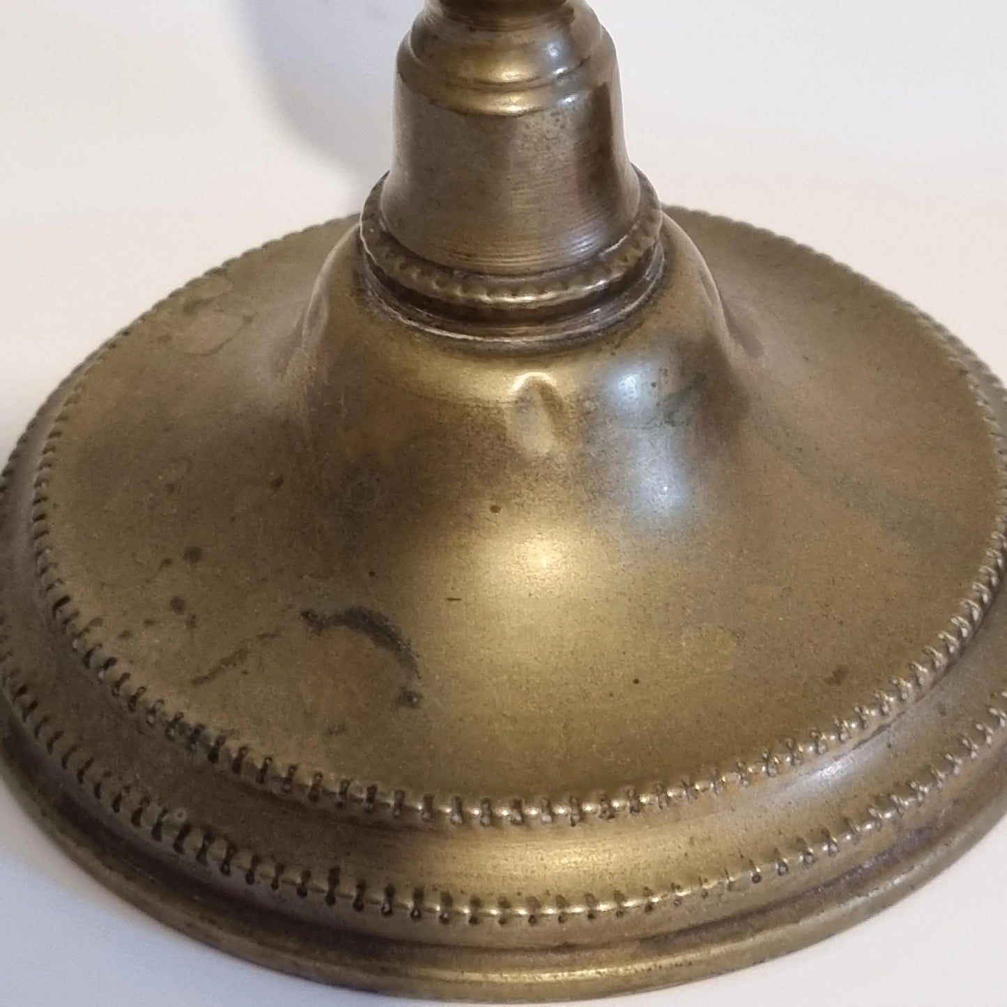 Vintage Brass Candle Holders: Hand-Painted European Village Scene, 1920s Pair showing detailed aged brass base with decorative edging.
