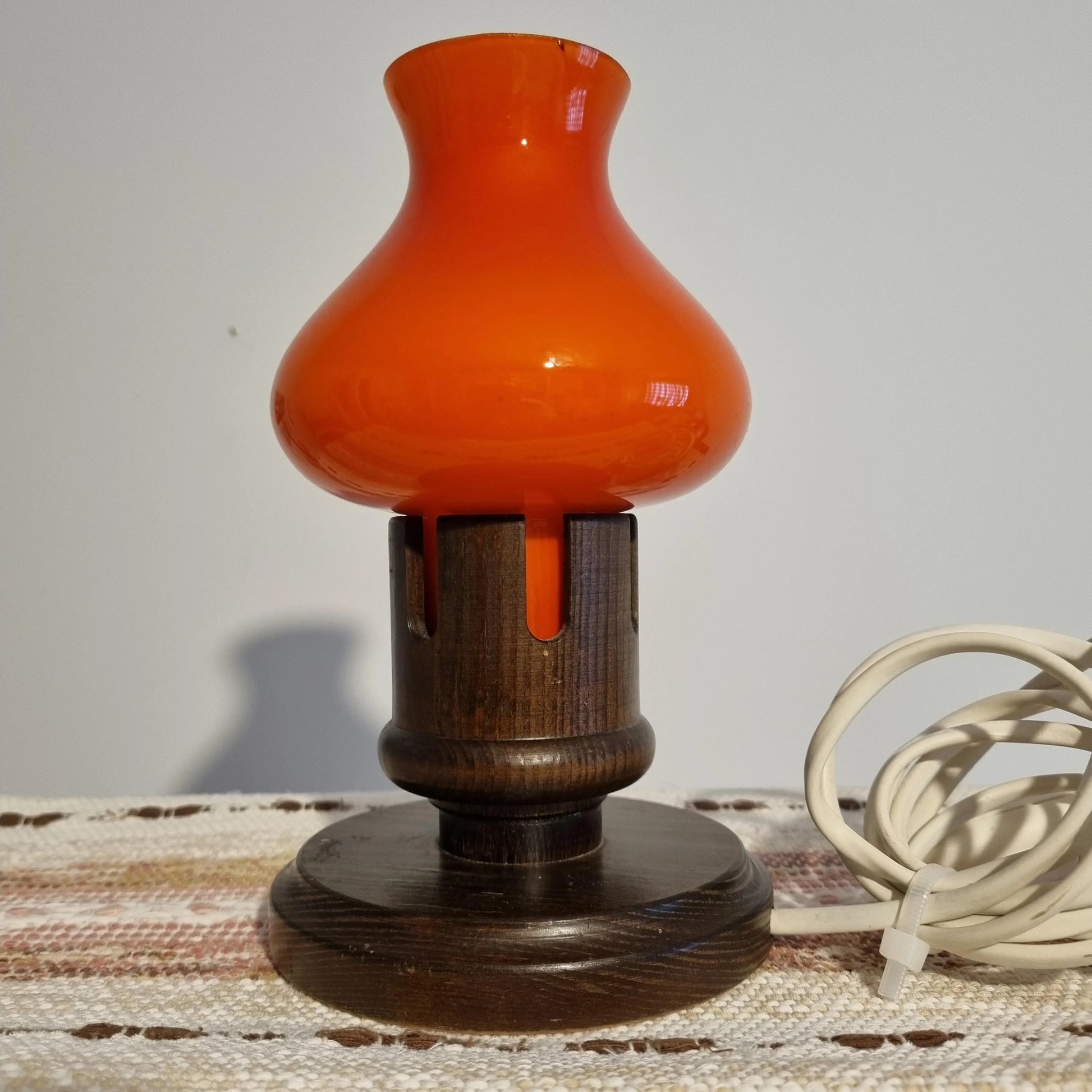 Vintage Erik Höglund Table Lamp – Orange Cased Glass & Pine, Marksöjd Boda, Sweden c. 1970 on woven textile background