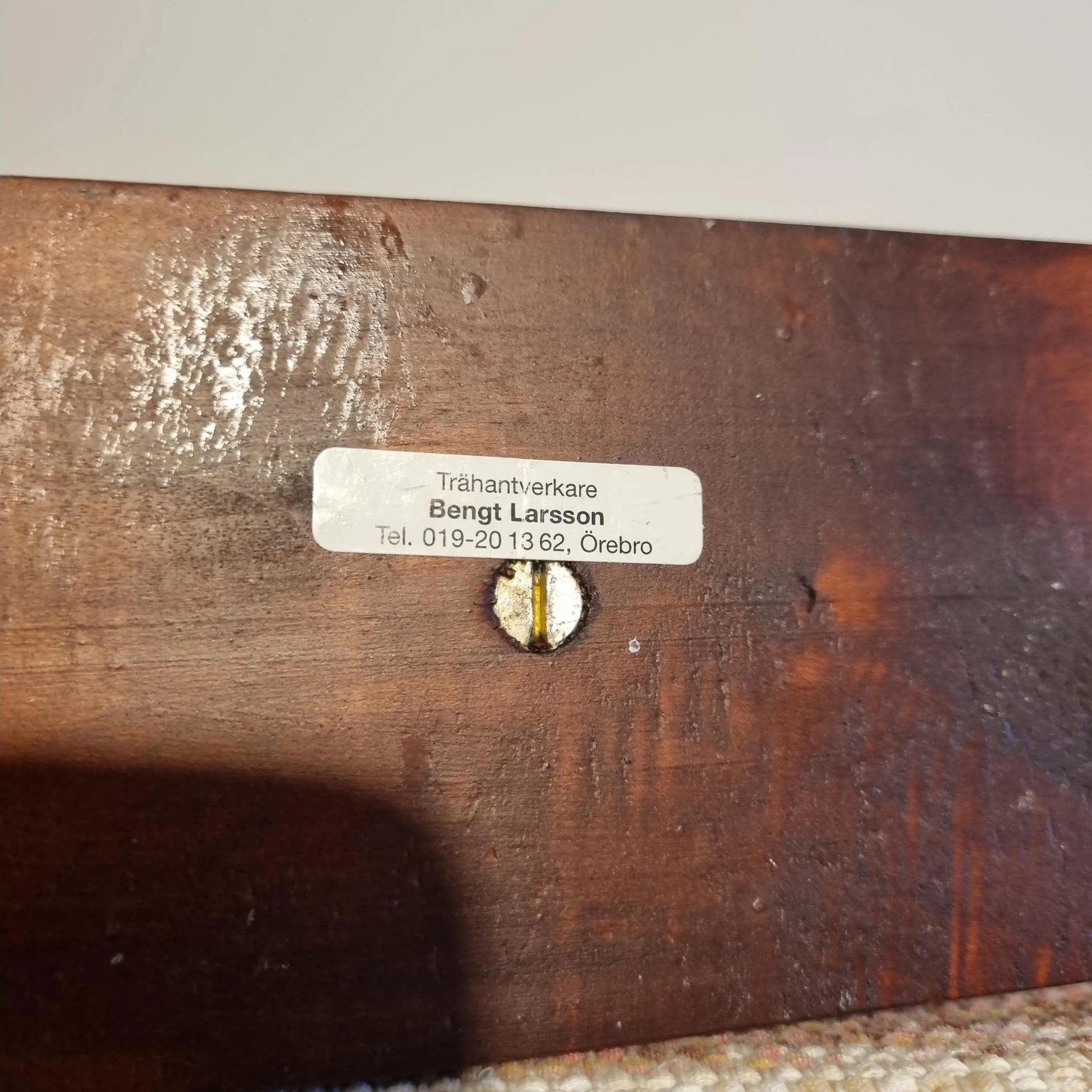 Close-up of authentic vintage Hand Carved Pine Candle Holder: Swedish Folk Art, Bengt Larsson showing wood grain and maker's label, timeless charm.