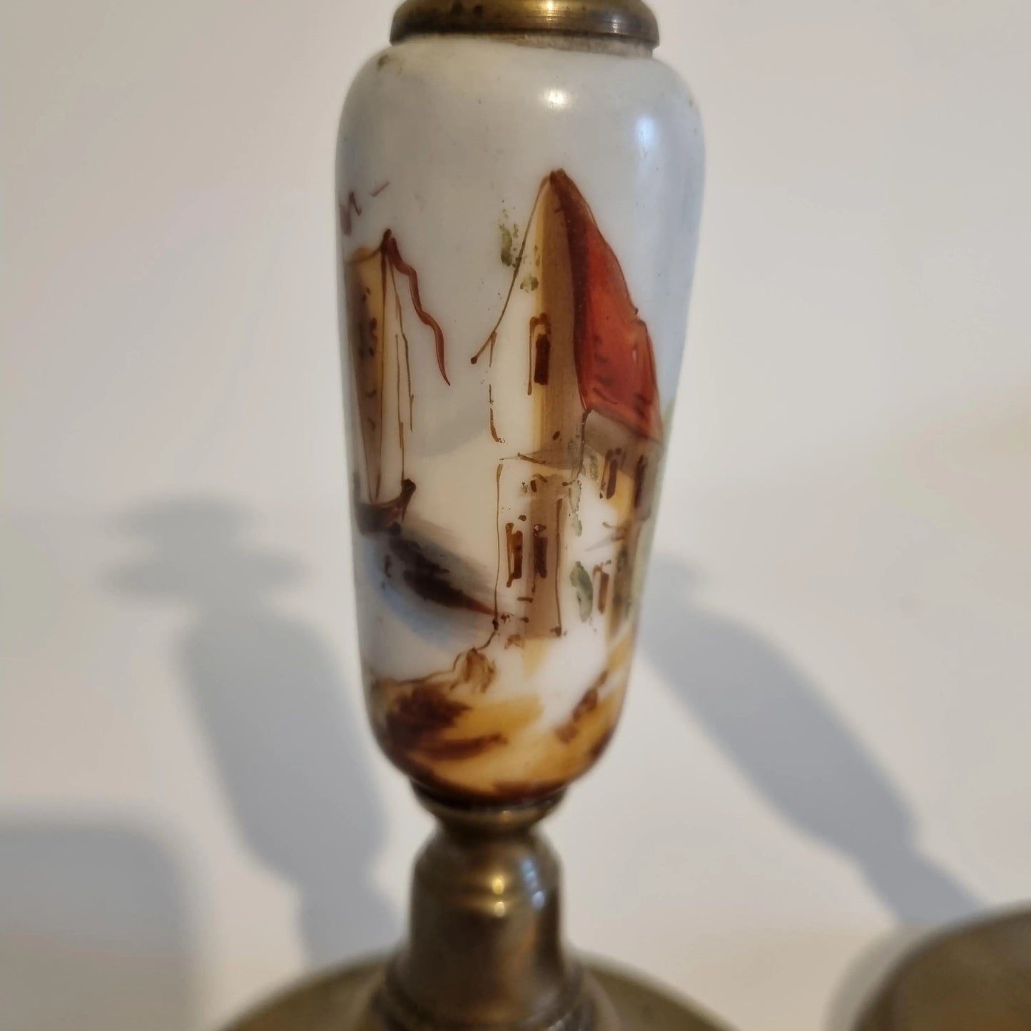 Vintage Brass Candle Holders: Hand-Painted European Village Scene, 1920s Pair featuring intricate village houses and red roofs detail.